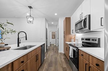 A modern kitchen with wooden cabinets and stainless steel appliances.
